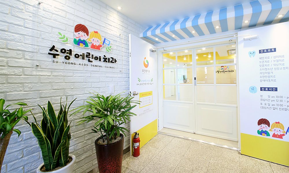 수영어린이치과 로고가 걸린 병원 입구와 유리문